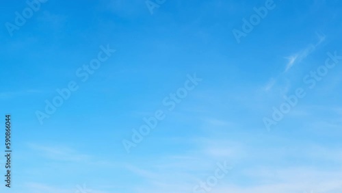 White cirrus and stratus clouds in a blue daytime sky, timelapse