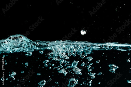 Water surface with bubbles on black background.