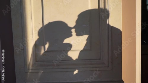 Shadow on yellow wall of building outdoors of couple in love looking to each other and kissing. Man and woman, sensual. Lovely family - bride and groom at the wedding.