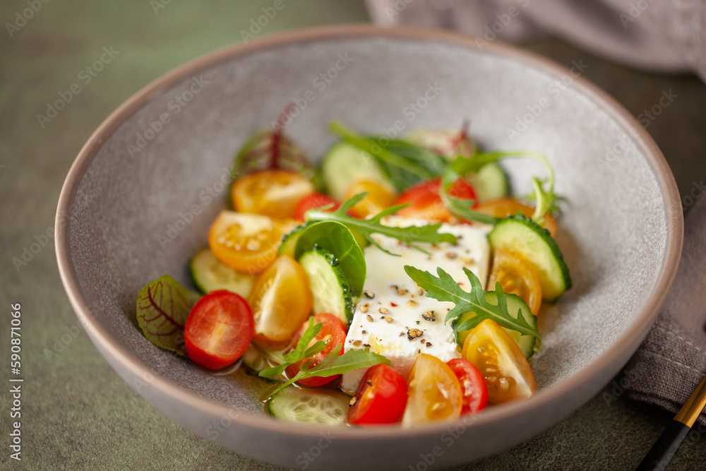 Easy greek salad of fresh cucumber, tomato, arugula,  feta cheese  with olive oil. Healthy food.