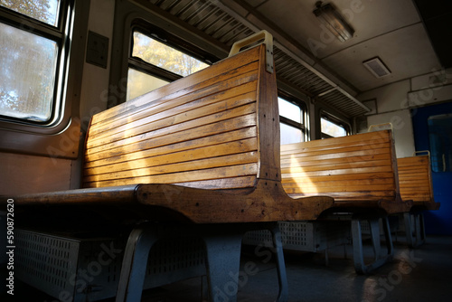 Old empty wagon of train. Wooden seats in an empty coach of train photo