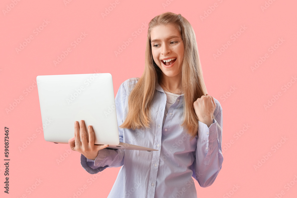 Naklejka premium Happy female programmer with laptop on pink background