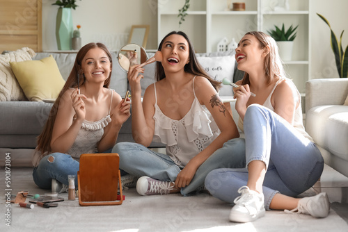 Young women doing makeup at...