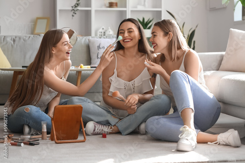 Young women doing makeup at...