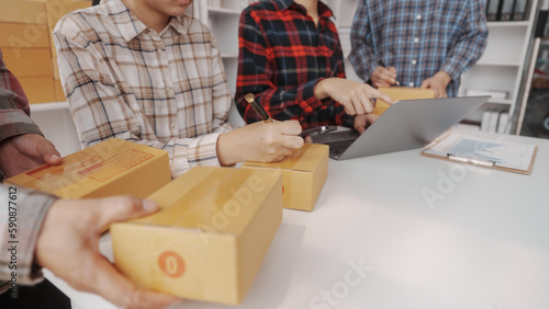 Team of smes warehouse checking email and writing on parcel cardboard box  Small business entrepreneur  SME  freelance online sellers  influencer and the team behind the work.