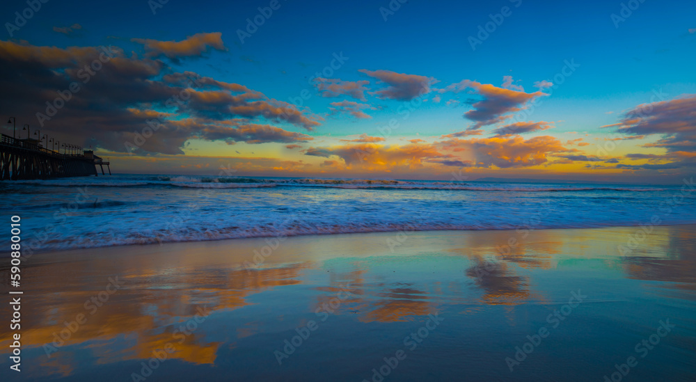 Winter Reflections: the sky reflects of the wet beach in San Diego, California at sunrise.