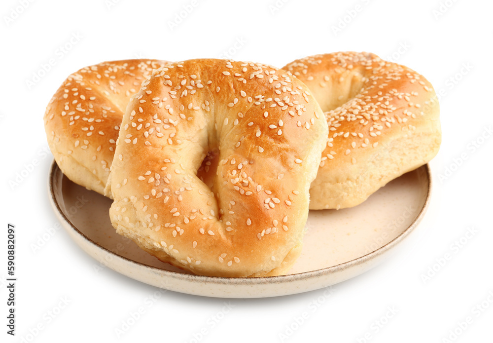 Plate of tasty bagels with sesame seeds on white background