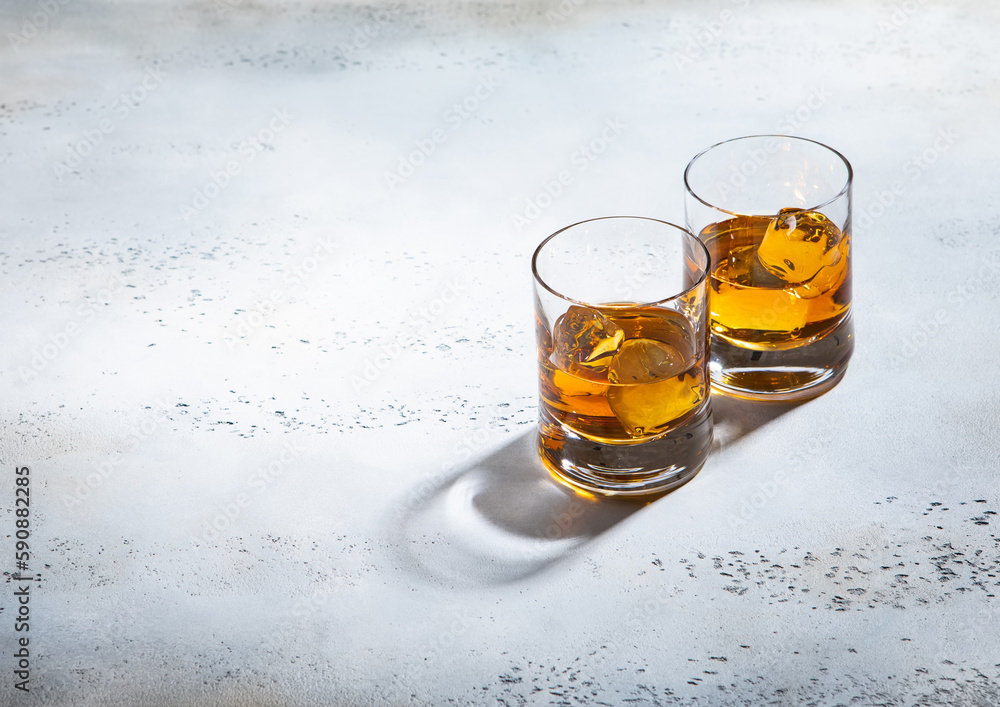 Glasses of single malt finest whiskey with ice cubes on light background. Glasses of single malt finest whiskey with ice cubes on light background.