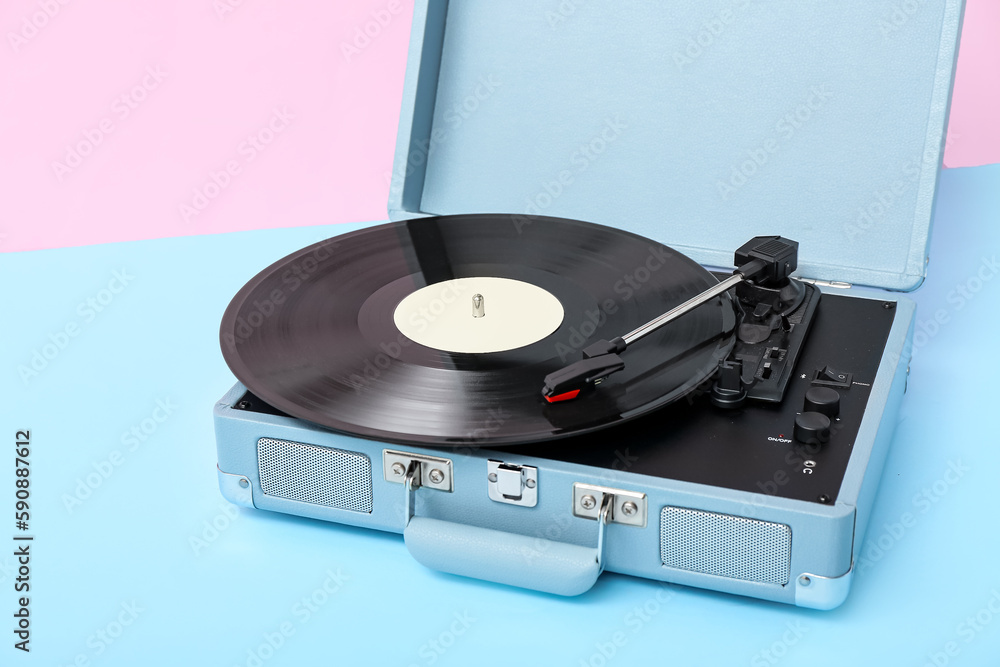 Record player with vinyl disk on table near pink wall Record player with vinyl disk on table near pink wall