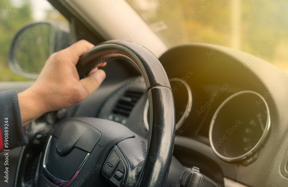 Driving with a car . View from car inside. Steering wheel with man hand