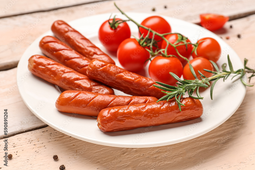 Plate with tasty grilled sausages and fresh tomatoes on light wooden background, closeup Plate with tasty grilled sausages and fresh tomatoes on light wooden background, closeup