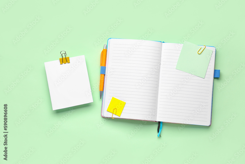 Sticky notes and notepad on green background Sticky notes and notepad on green background