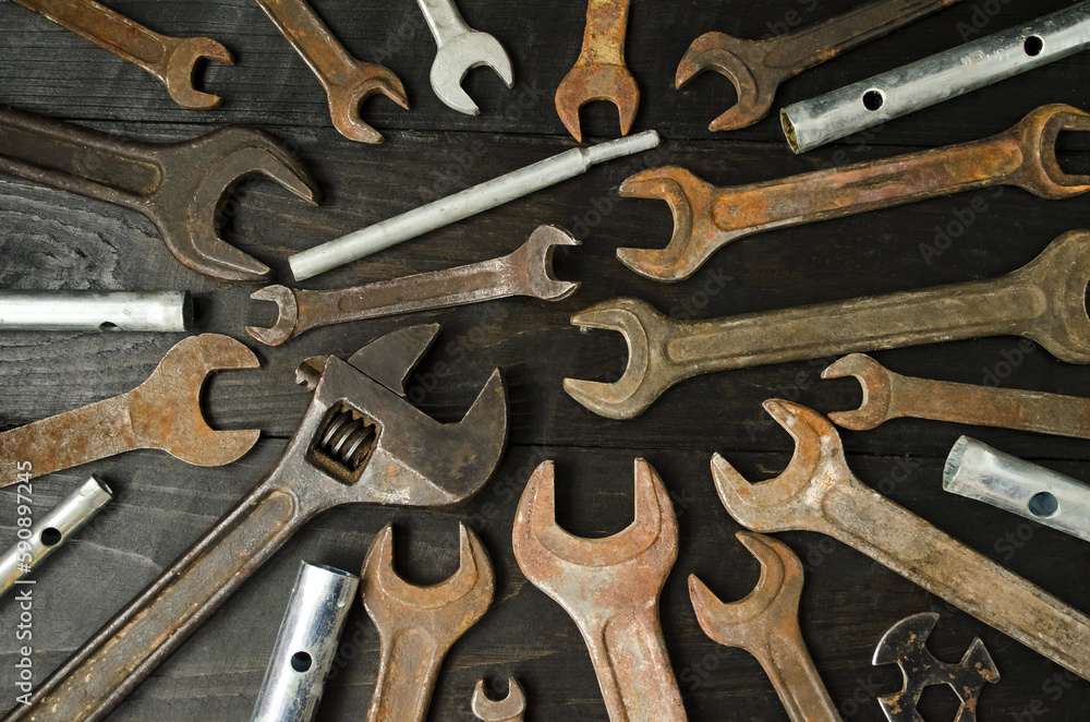 There are many different wrenches of different sizes on a wooden background. Concept design and hand tools. Flat lay, top view, close up. There are many different wrenches of different sizes on a wooden background. Concept design and hand tools. Flat lay, top view, close up.
