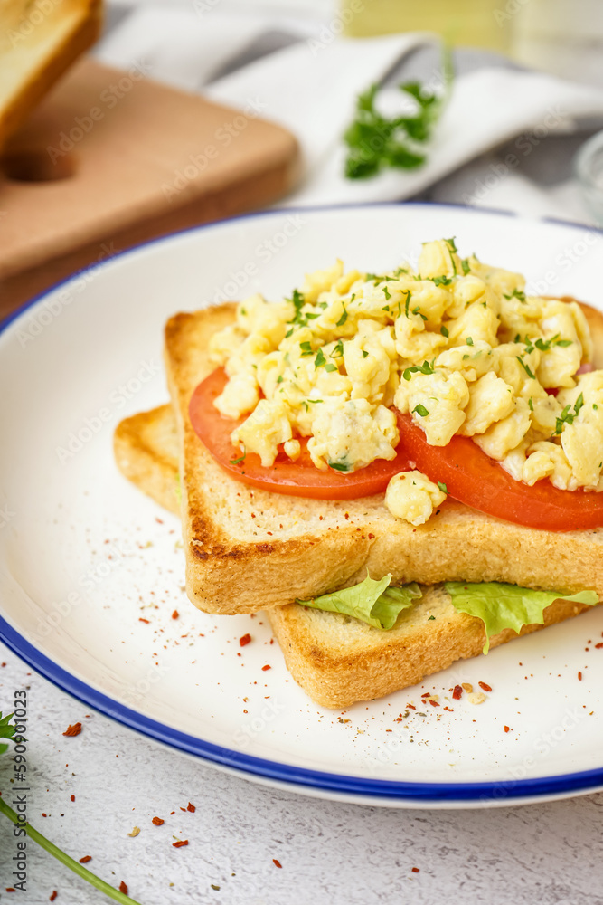 Plate with tasty scrambled eggs sandwich on table Plate with tasty scrambled eggs sandwich on table