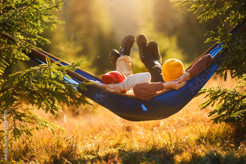 Fotografi Children lie in a tourist hammock in the forest