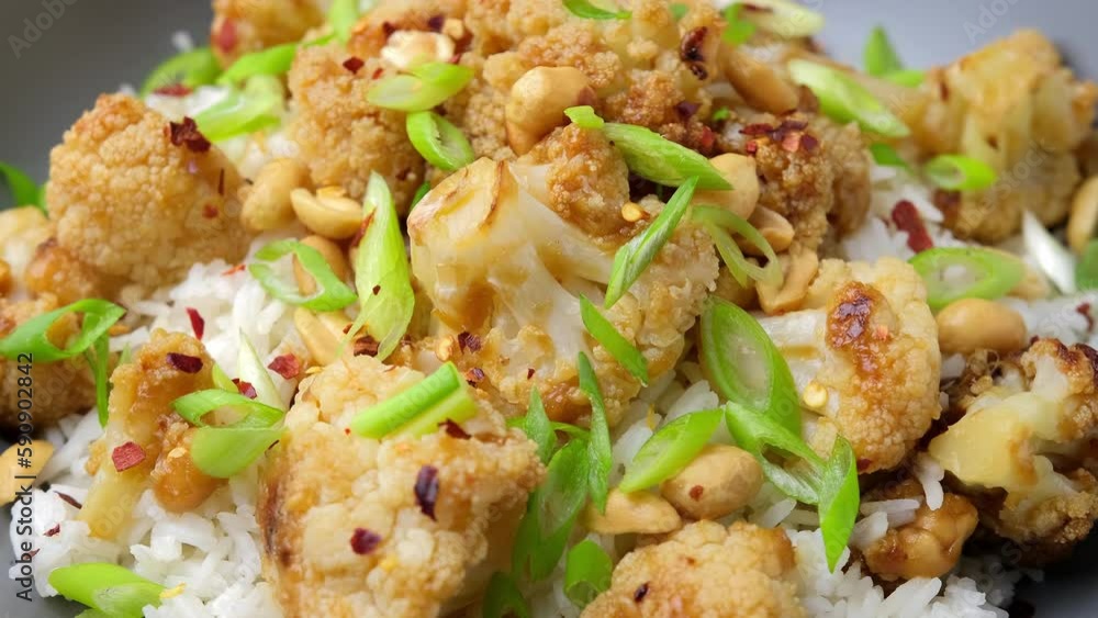Kung Pao Cauliflower with rice, peanuts and spices. Healthy vegan food. Rotating video Kung Pao Cauliflower with rice, peanuts and spices. Healthy vegan food. Rotating video