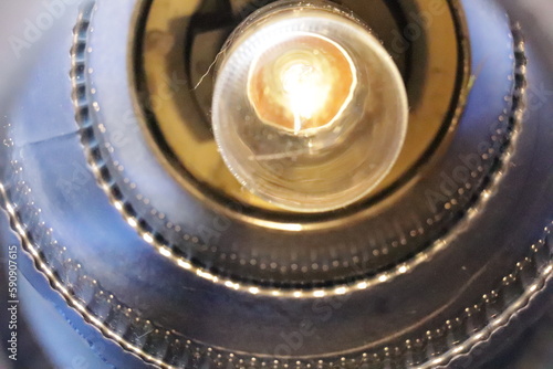 Inside of a light with the bulb illuminated showing the glass pattern on the light shade.