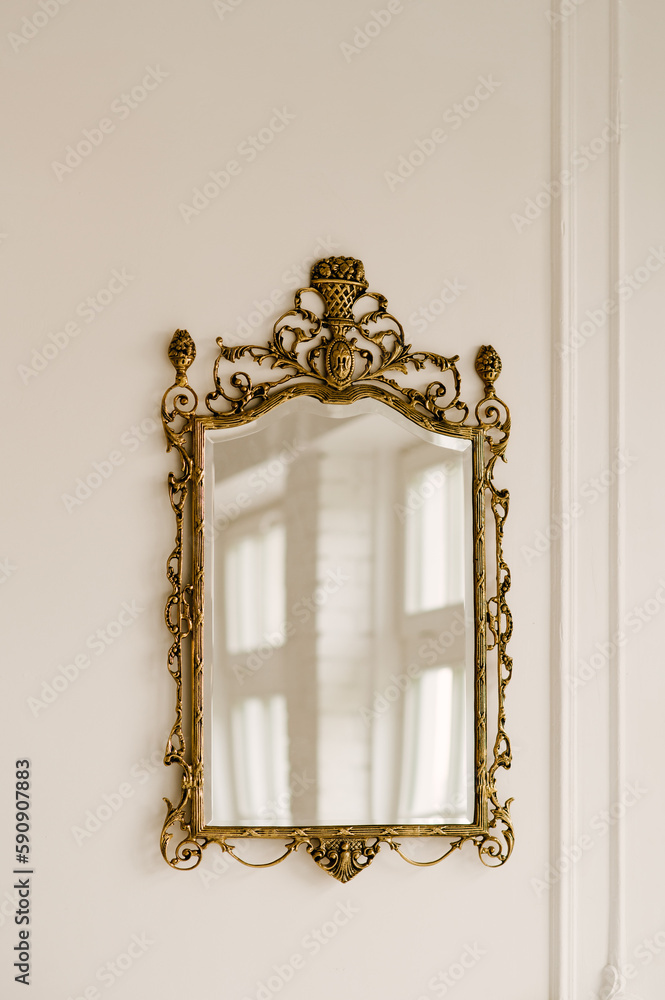 Gold vintage mirror on a white wall background