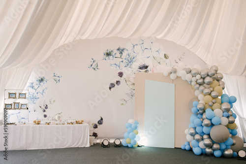 Obraz na płótnie A large photo zone with blue and white balloons and a candy bar in a white tent w salonie