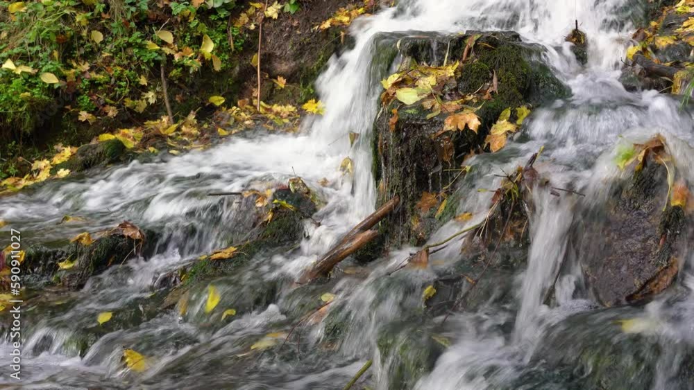 Rocky waterfall during autumn leaf fall Rocky waterfall during autumn leaf fall