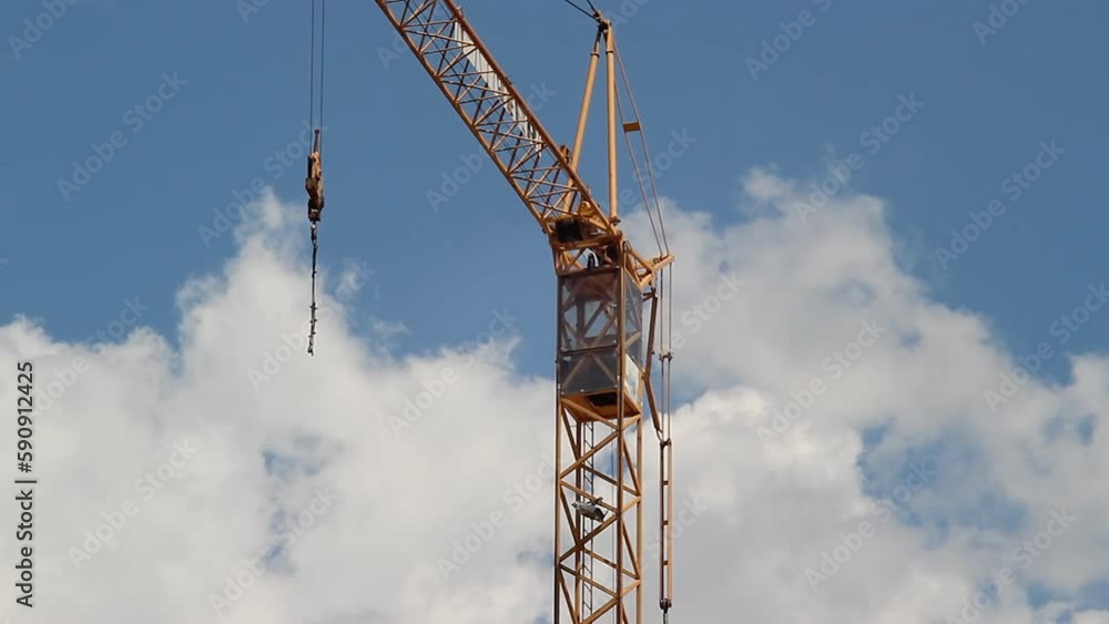A construction crane with a blue sky and clouds in the background. Time-lapse video. A construction crane with a blue sky and clouds in the background. Time-lapse video.