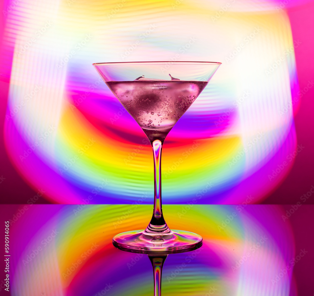 Alcoholic cocktail in a glass goblet against the background of colorful neon lights Alcoholic cocktail in a glass goblet against the background of colorful neon lights