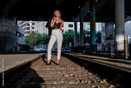 A Lovely Blonde Model Poses On Railroad Tracks At Sunset