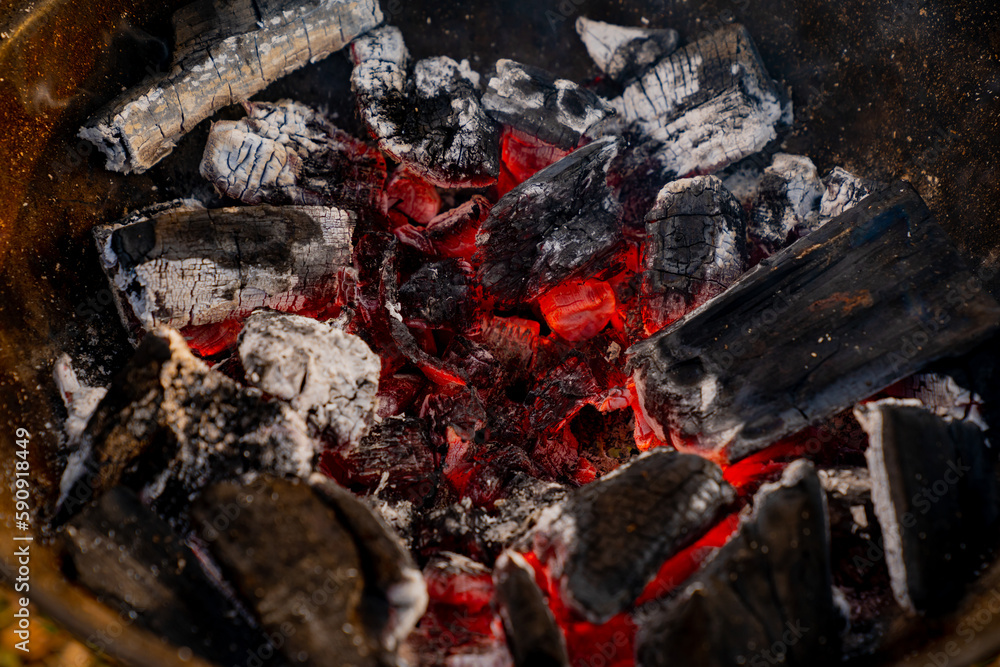 Red hot coals burning in high temperature and turning to white ash close up in metal mangal grill Red hot coals burning in high temperature and turning to white ash close up in metal mangal grill