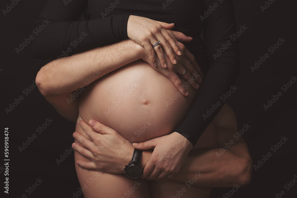 Pregnant woman and her husband holding hand together, 2 hands holding baby inside a pregnant woman, love of family, Parenting.Family lifestyle of pregnancy. Expecting new baby.