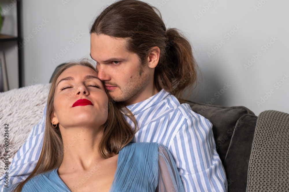 Idyll. Happy couple enjoying the moment. A man in a striped shirt hugs a woman with long hair, red lips and nails, in an airy dress. Copy space. Background for quotes Idyll. Happy couple enjoying the moment. A man in a striped shirt hugs a woman with long hair, red lips and nails, in an airy dress. Copy space. Background for quotes