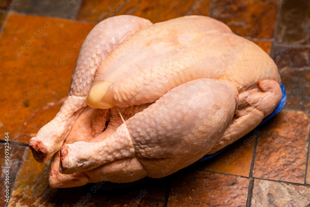 Fototapeta premium Whole whole chicken carcass on stone tile background.