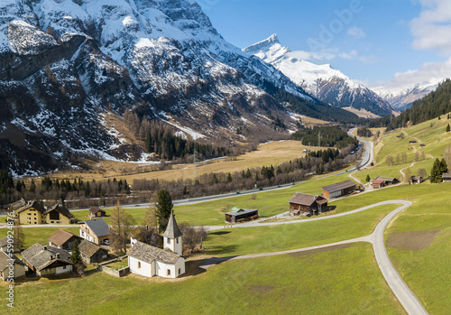 Areal image of the idyllic Alps village of Medels im Rheinwald with the reformed church Medels and the Alps peak Einshorn at the background, Grisons, Switzerland