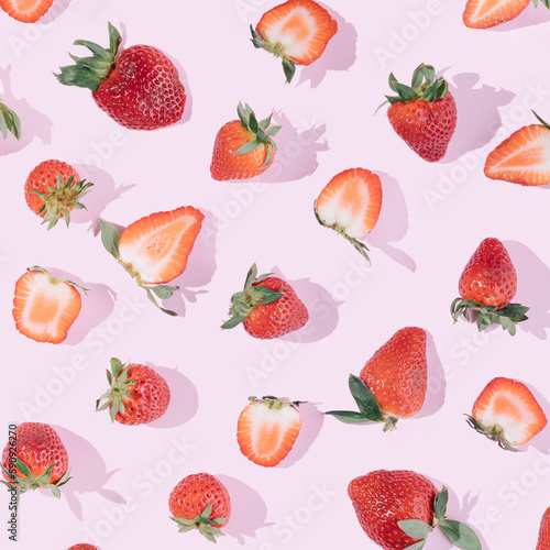 Fototapeta Naklejka Na Ścianę i Meble -  Summer fruit pattern made of fresh strawberries on a pink background. Juicy aesthetic wallpaper.