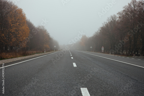 Empty long mountain road to the horizon on a sunny summer day at bright sunset - speed motion blur effect