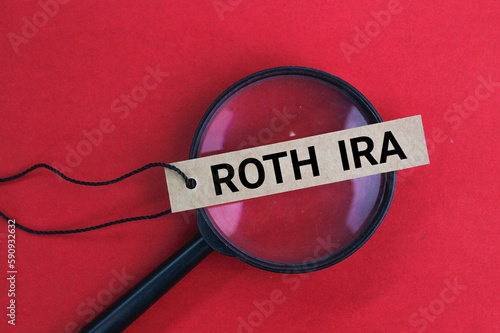 magnifying glass and tag with the word ROTH IRA. business concept
