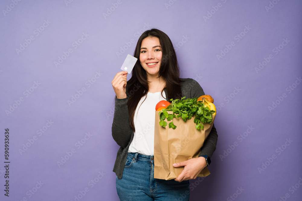 Attractive woman using a credit card grocery shopping Attractive woman using a credit card grocery shopping