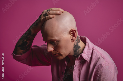 tattooed bald man, sorry, pink background, Generative AI