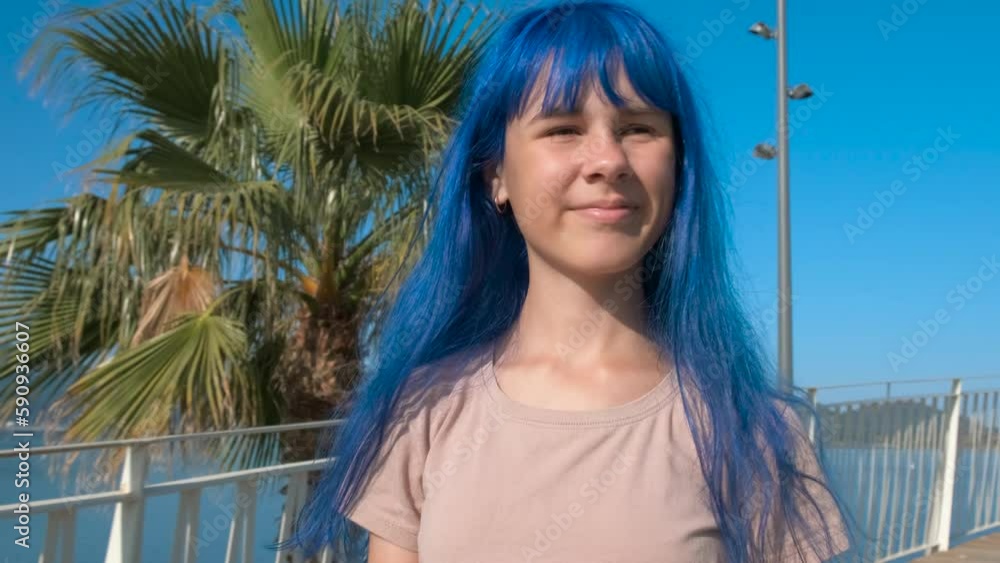Blue girl at amazing sea park. A blue haired girl have amazing time against tropical park in the sun. Blue girl at amazing sea park. A blue haired girl have amazing time against tropical park in the sun.
