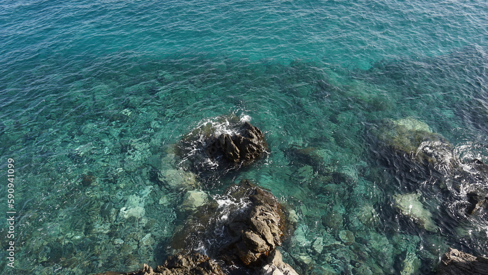 Fototapeta premium Crystal clear ocen water with volcanic rocks visible on the bottom in Tenerife, Canary Islands, Spain