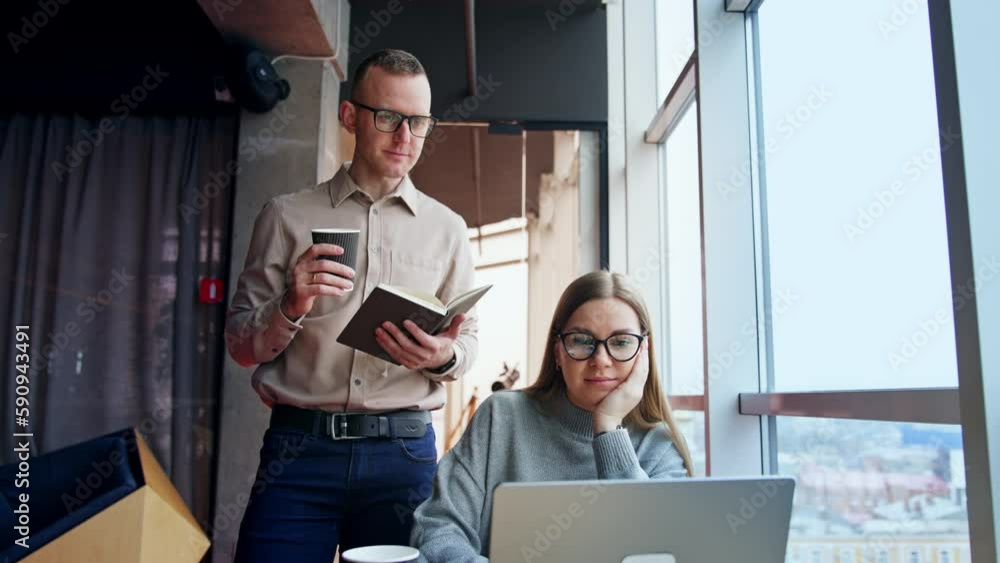 Office teammates look at laptop discussing work. Colleagues consulting, advising and helping each other. Lunch time at workplace. Office teammates look at laptop discussing work. Colleagues consulting, advising and helping each other. Lunch time at workplace.