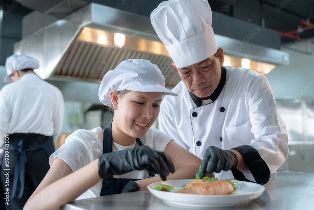 Male chefs train female apprentices in a cooking class.