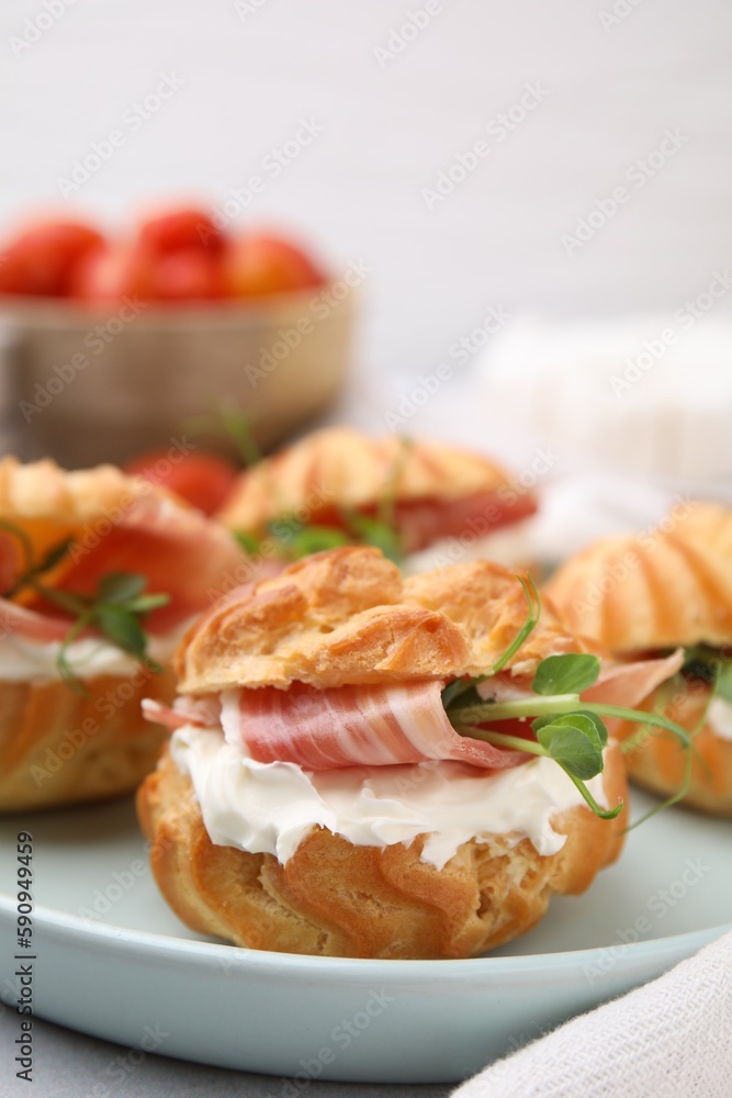 Delicious profiteroles with cream cheese and prosciutto on plate, closeup Delicious profiteroles with cream cheese and prosciutto on plate, closeup