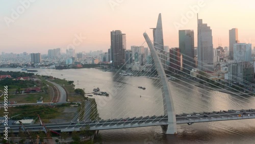 Aerial shot of cable-stayed road bridge over the river, downtown in the background. Scenic panorama of cityscpae at dawn photo
