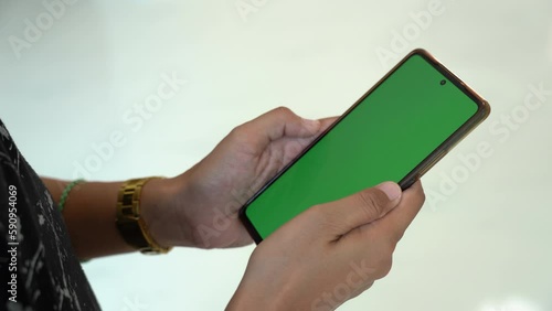 Hand holding smartphone green screen