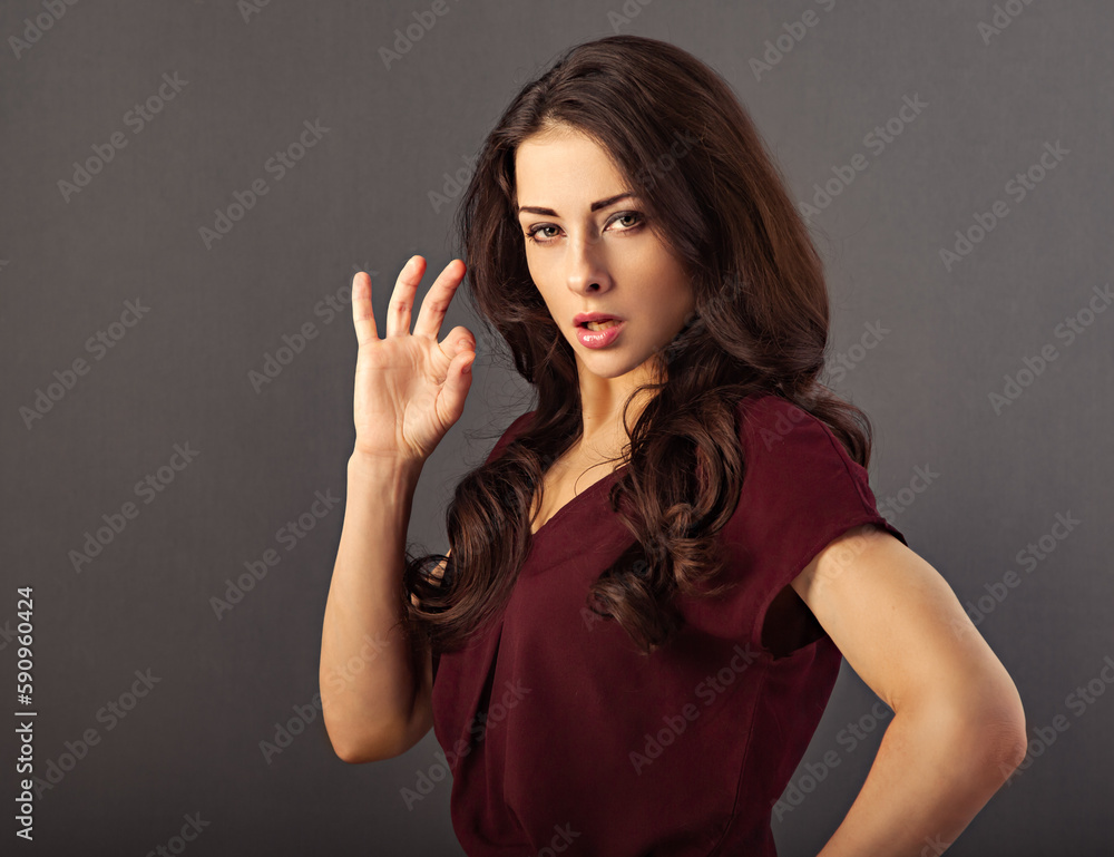 Beautiful makeup success serious business woman in red blouse showing ok cool sign by hand and looking concentrated. Closeup Beautiful makeup success serious business woman in red blouse showing ok cool sign by hand and looking concentrated. Closeup