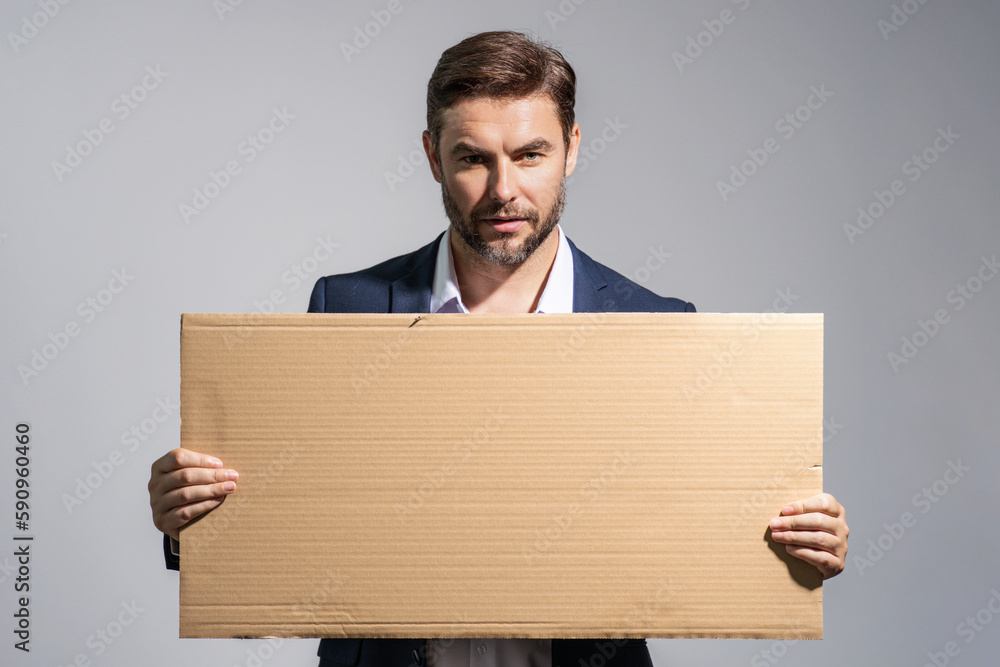 Serious man holds the sign, blank card. Placard ready for your product. Sign to your text. Handsome man showing blank sign board over studio background. Empty blank board. Area advertising. Serious man holds the sign, blank card. Placard ready for your product. Sign to your text. Handsome man showing blank sign board over studio background. Empty blank board. Area advertising.