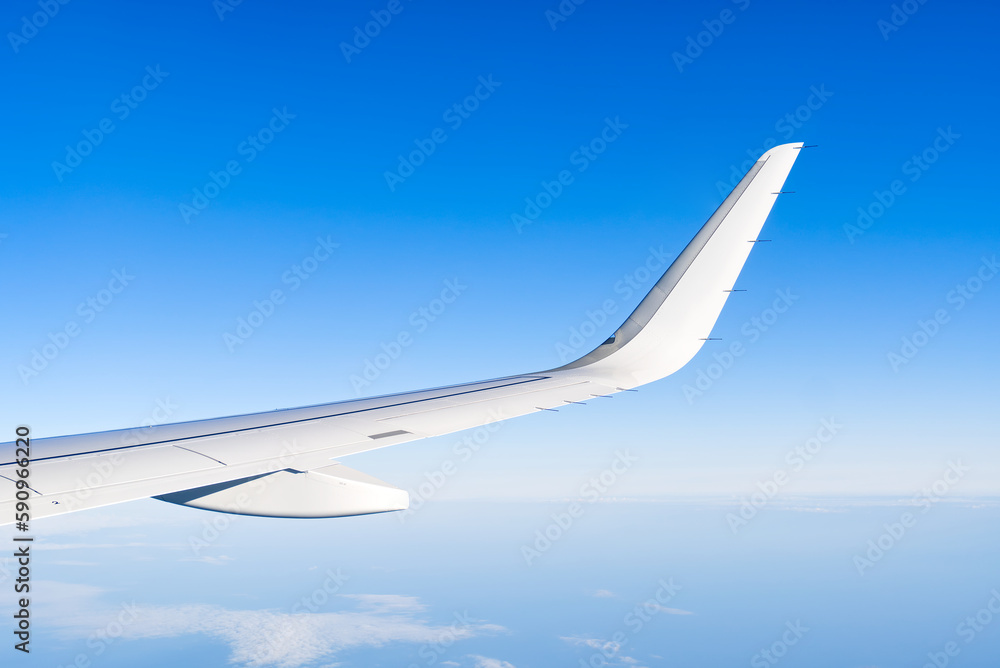 Airplain wing view thrue window in the sky. Clouds and sky as seen through porthole of an aircraft with airplane's wing Airplain wing view thrue window in the sky. Clouds and sky as seen through porthole of an aircraft with airplane's wing