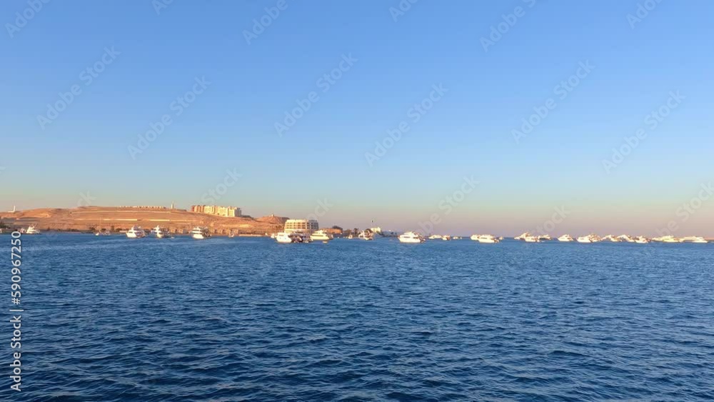 Shot of luxury yachts, motor and sailing boats docked in the marina during evening time. Shot of luxury yachts, motor and sailing boats docked in the marina during evening time.