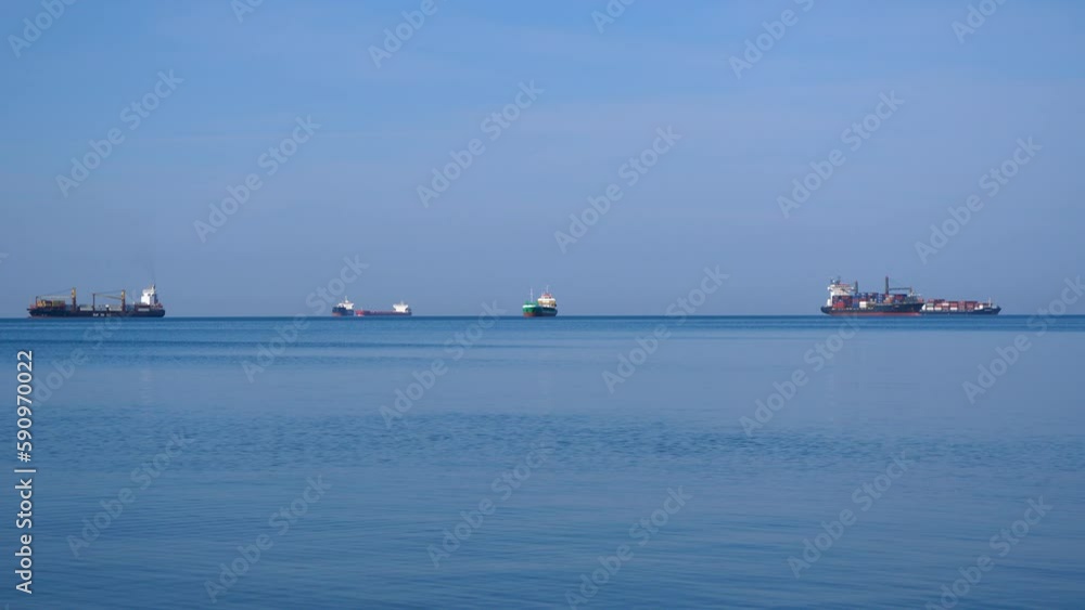 Tanker and cargo ships waiting out on a calm sea under cloud cover. Tanker and cargo ships waiting out on a calm sea under cloud cover.