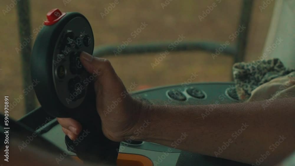 Farmer operating harvester lever.